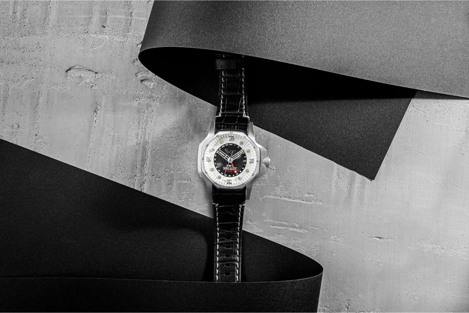 Vostok Europe Atomic Age oversized watch with a white and black multi-layered dial, stainless steel case and black leather strap displayed against an abstract monochrome background